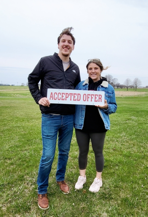 Couple holding Accepted Offer sign