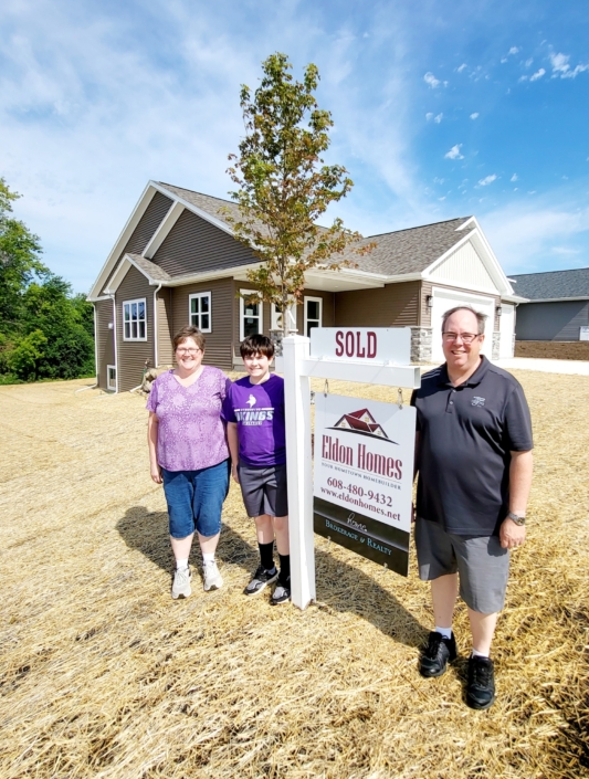 Family standing outside of a newly sold home